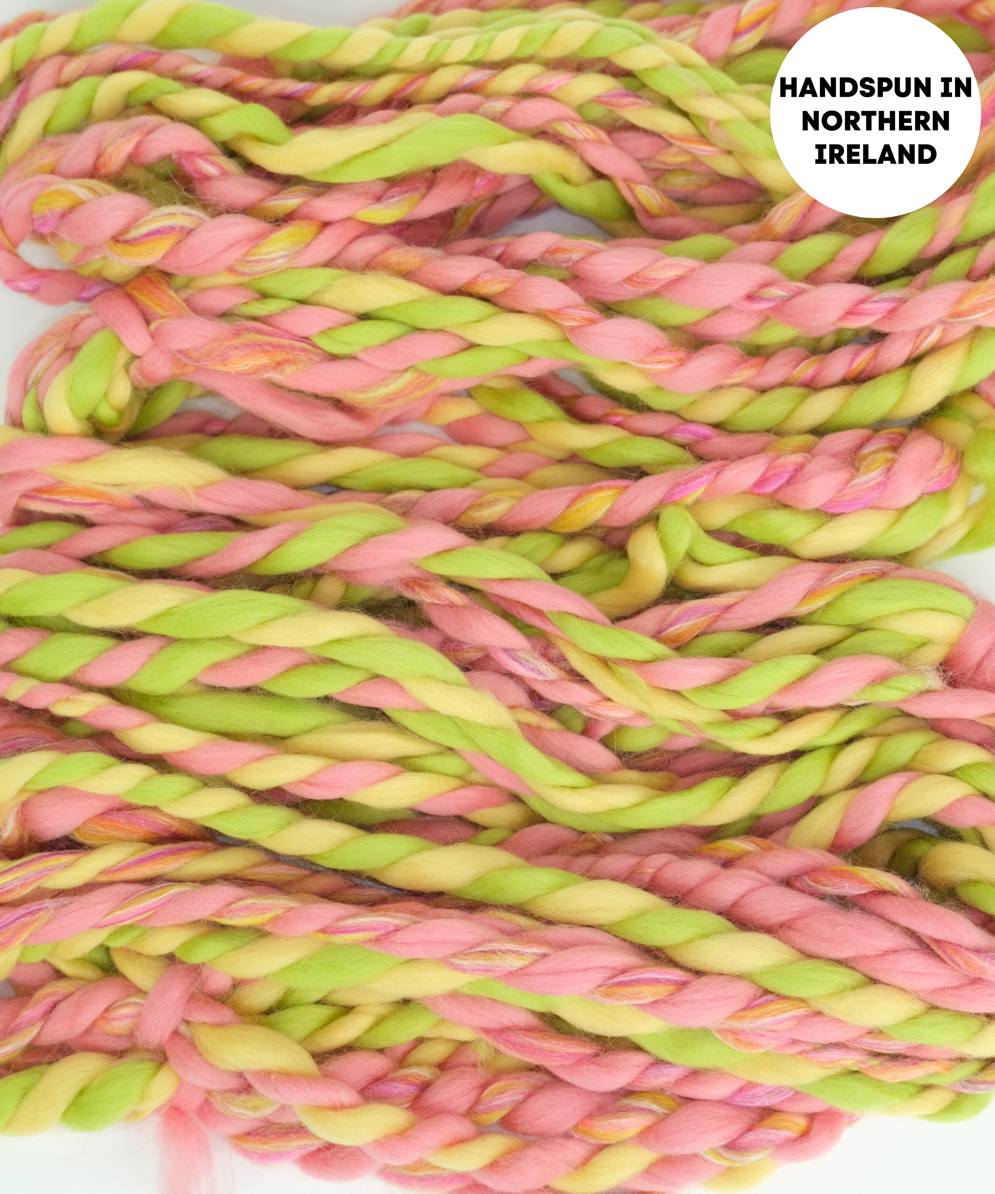 Handspun yarn in pink and green with 'Handspun in Northern Ireland' text overlay.