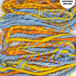 Handspun yarn in blue, orange, and yellow with 'Handspun in Northern Ireland' label.