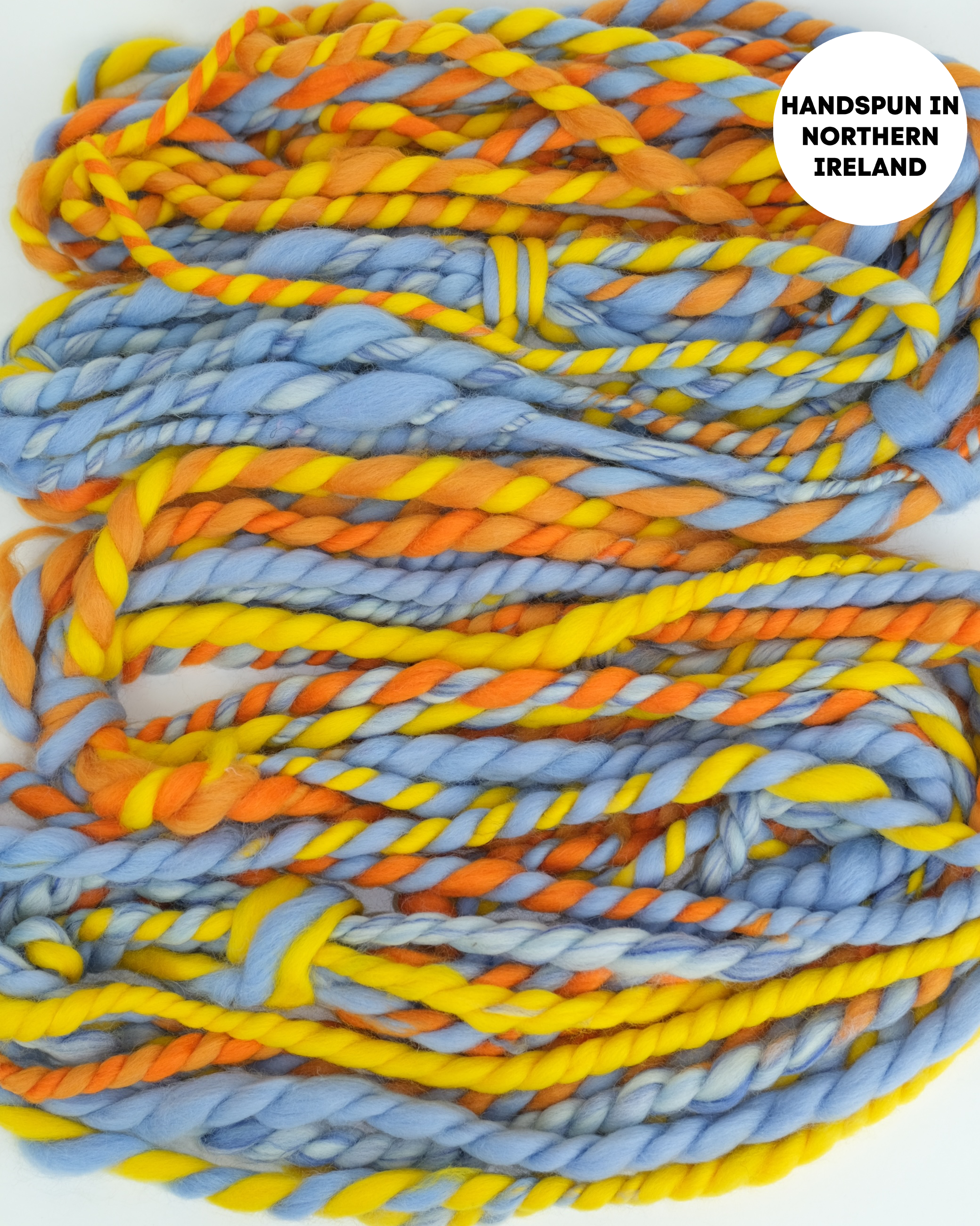 Handspun yarn in blue, orange, and yellow with 'Handspun in Northern Ireland' label.