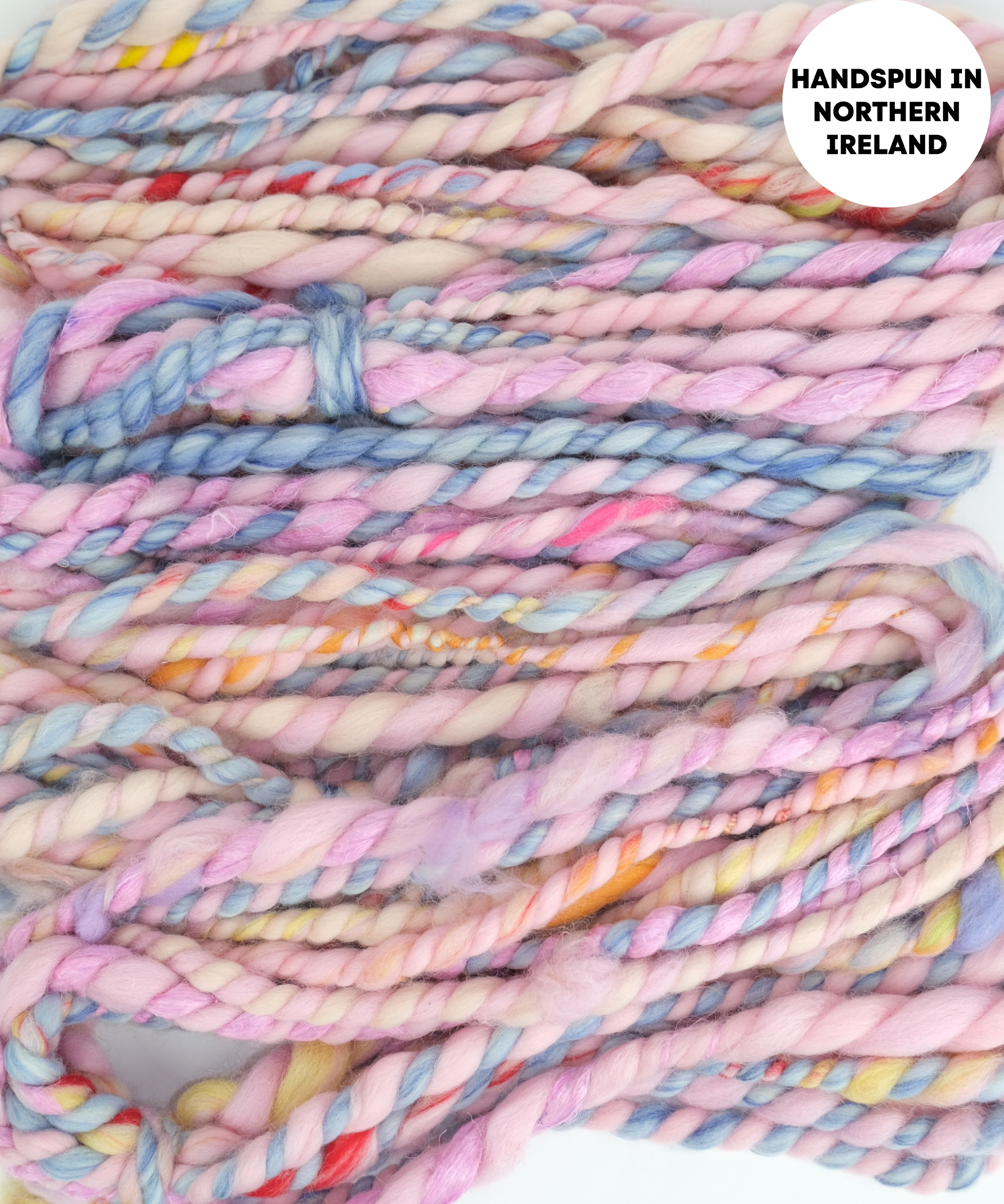 Handspun yarn with pastel colors and text 'Handspun in Northern Ireland' on a white background