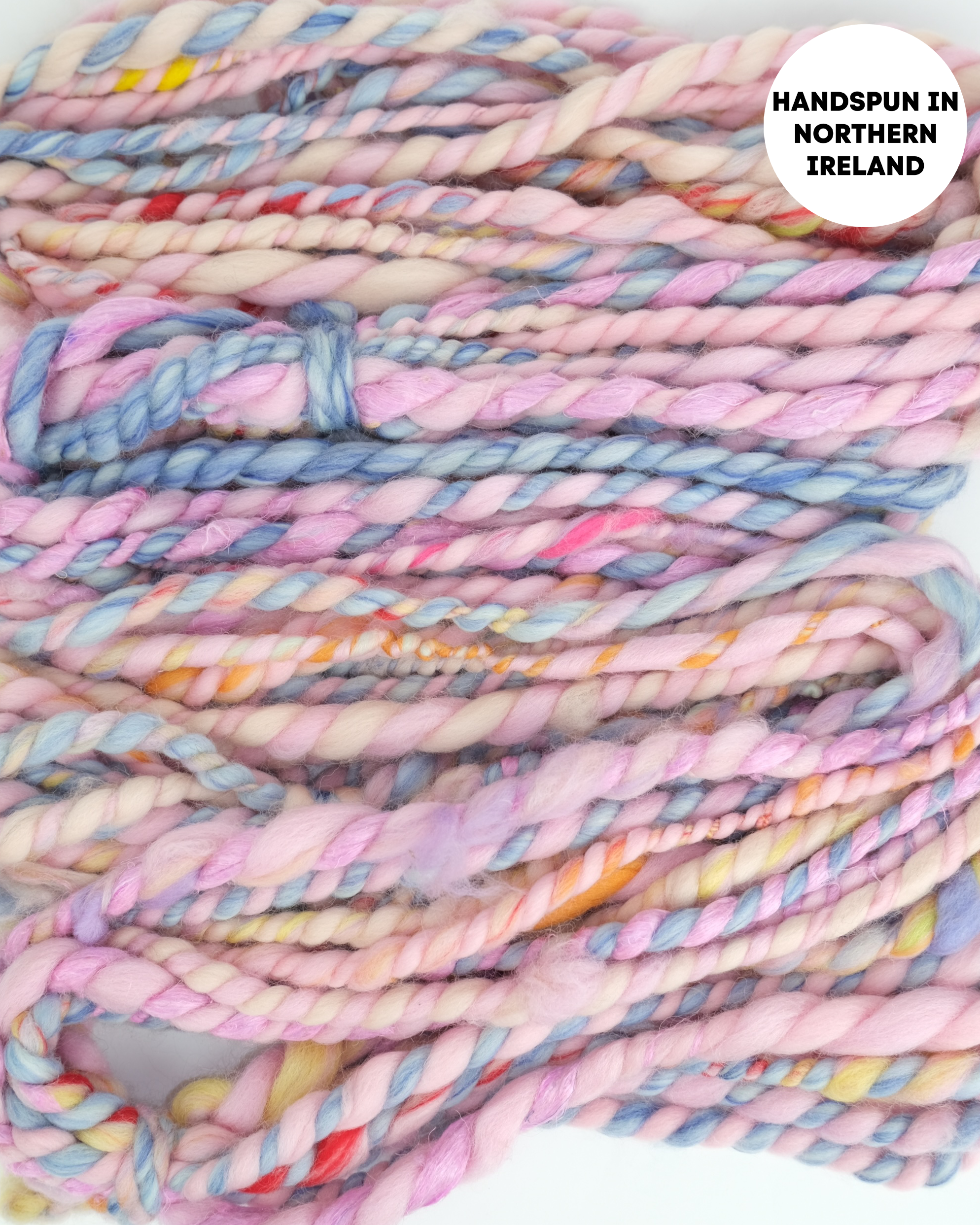 Handspun yarn with pastel colors and text 'Handspun in Northern Ireland' on a white background