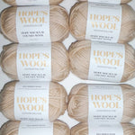 An arrangement of creamy-colored Merino wool balls neatly lined up in a row.