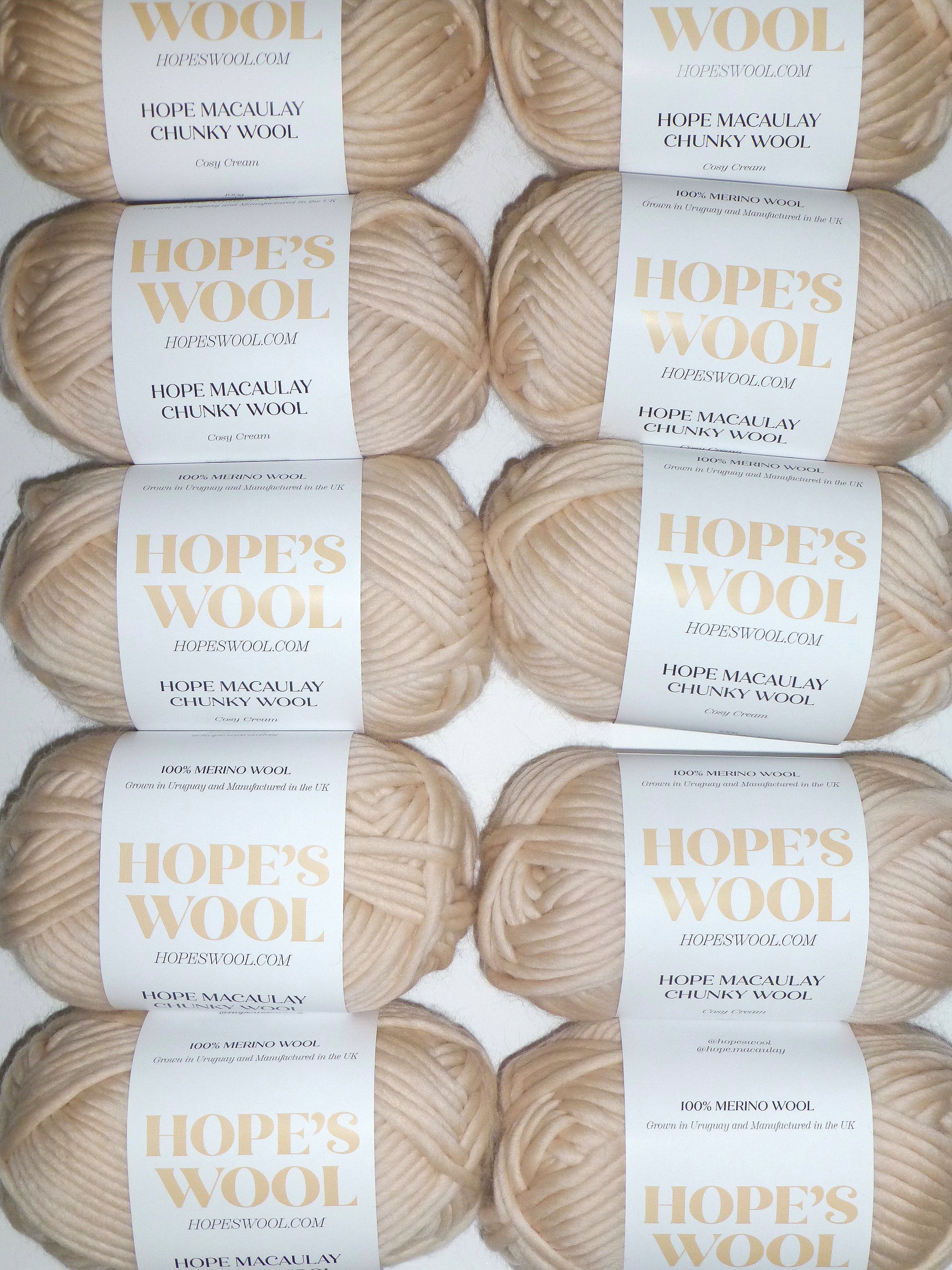 An arrangement of creamy-colored Merino wool balls neatly lined up in a row.