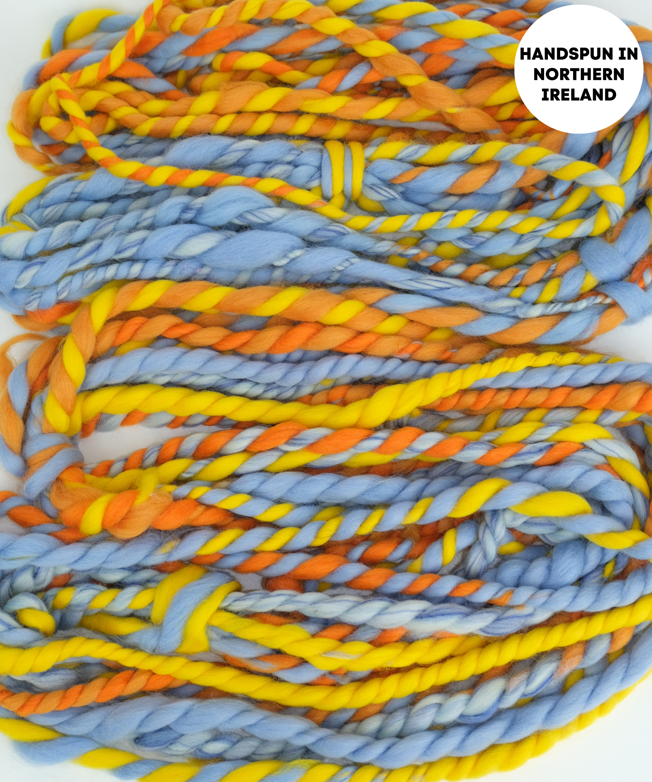 Handspun yarn in blue, orange, and yellow with 'Handspun in Northern Ireland' label.