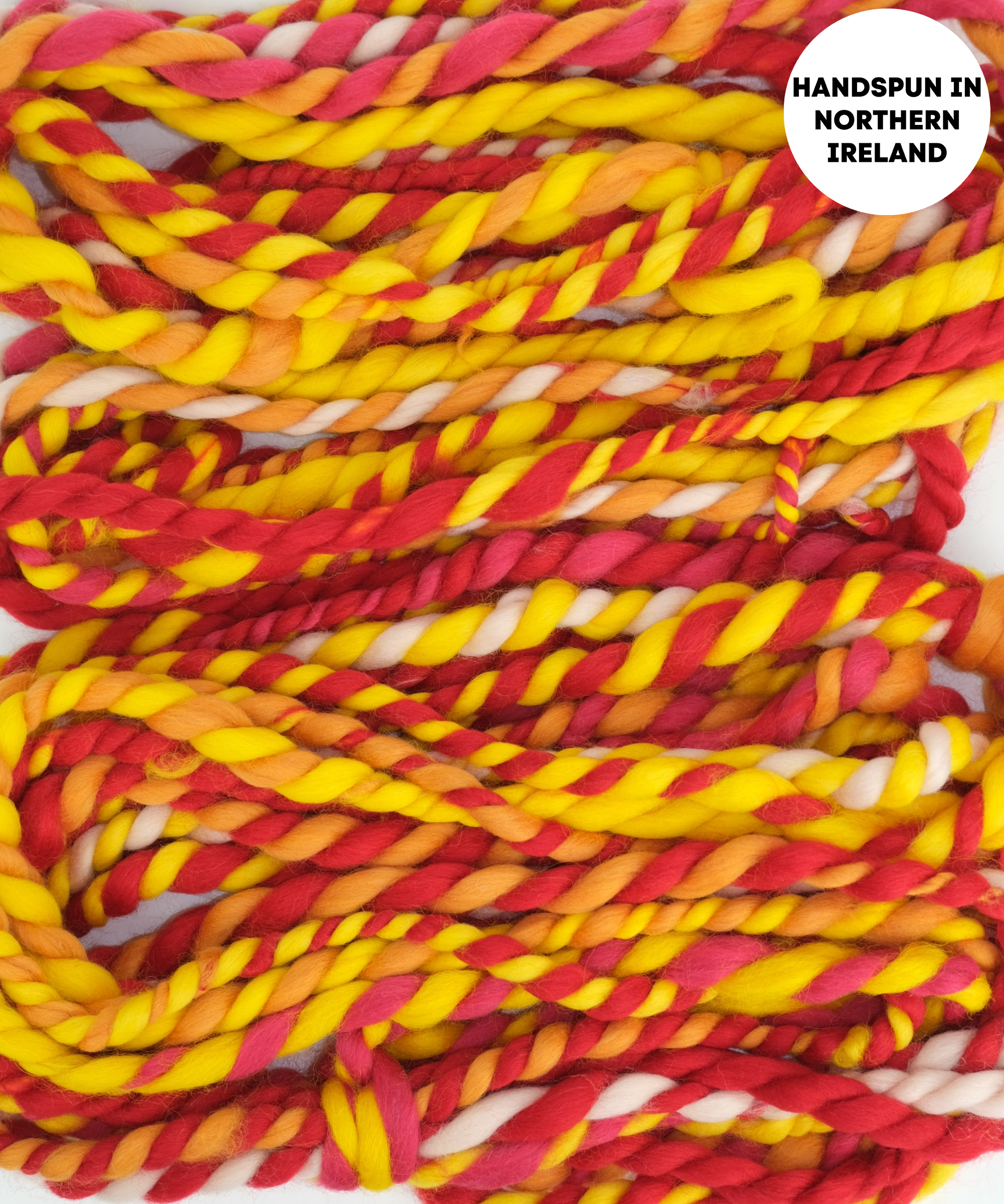 Handspun yarn in red, yellow, and orange on a white background with 'Handspun in Northern Ireland' text.