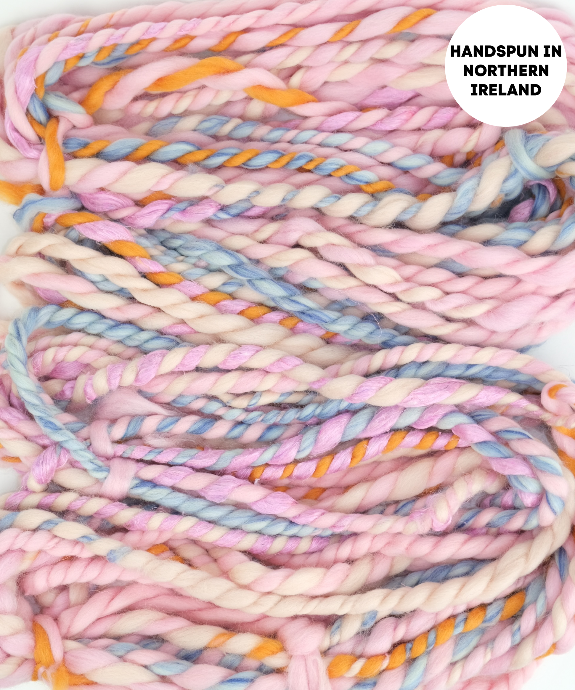 Handspun yarn with pastel colors on a white background, labeled 'Handspun in Northern Ireland'.