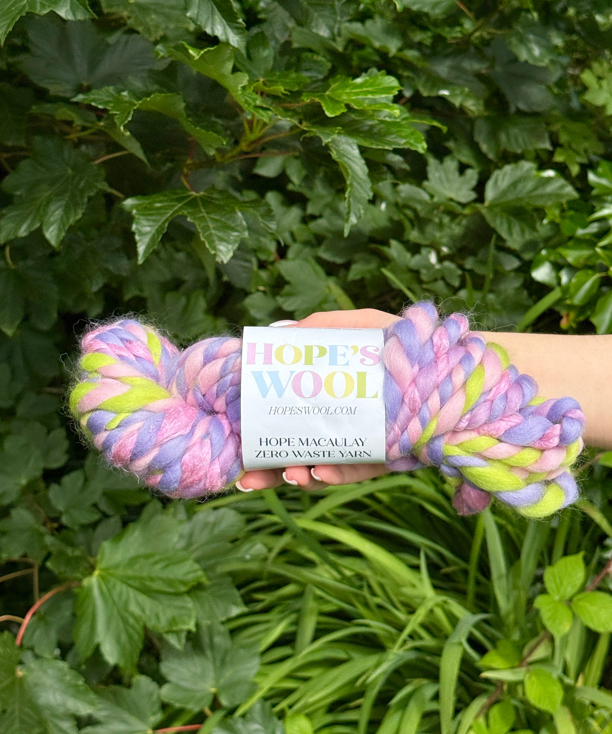 Braided yarn with a Hope's Wool label against a green leafy background