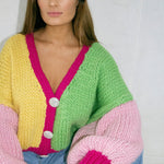 A woman wearing a colourful knitted cardigan.