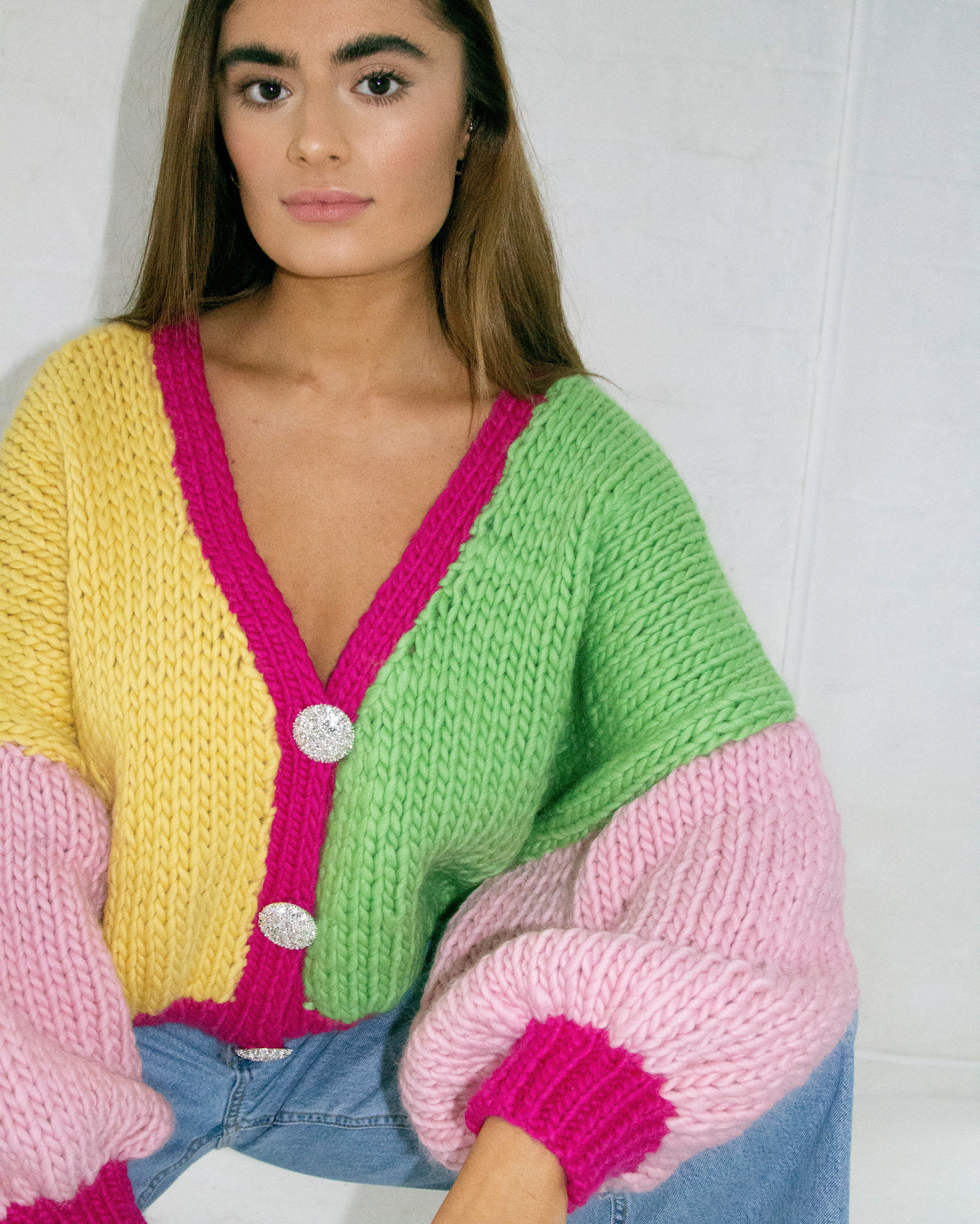 A woman wearing a colourful knitted cardigan.