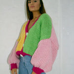 A woman wearing a colourful knitted cardigan.