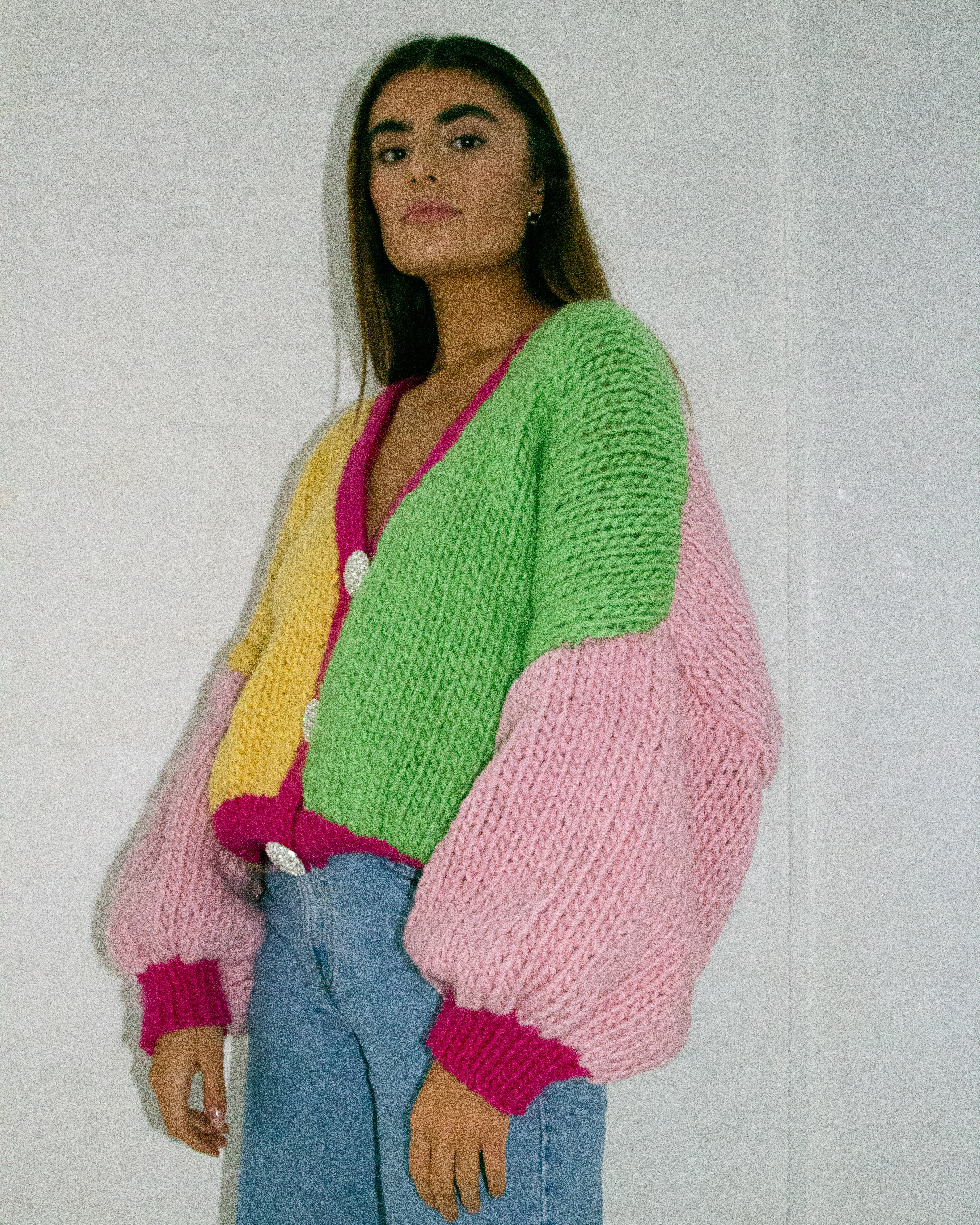 A woman wearing a colourful knitted cardigan.