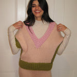 A woman wearing a colourful green, pink and cream vest