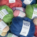 Balls of Corriedale wool in Pink, Blue and Green sitting on a mirror