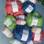 Balls of Corriedale wool in Pink, Blue and Green sitting on a mirror