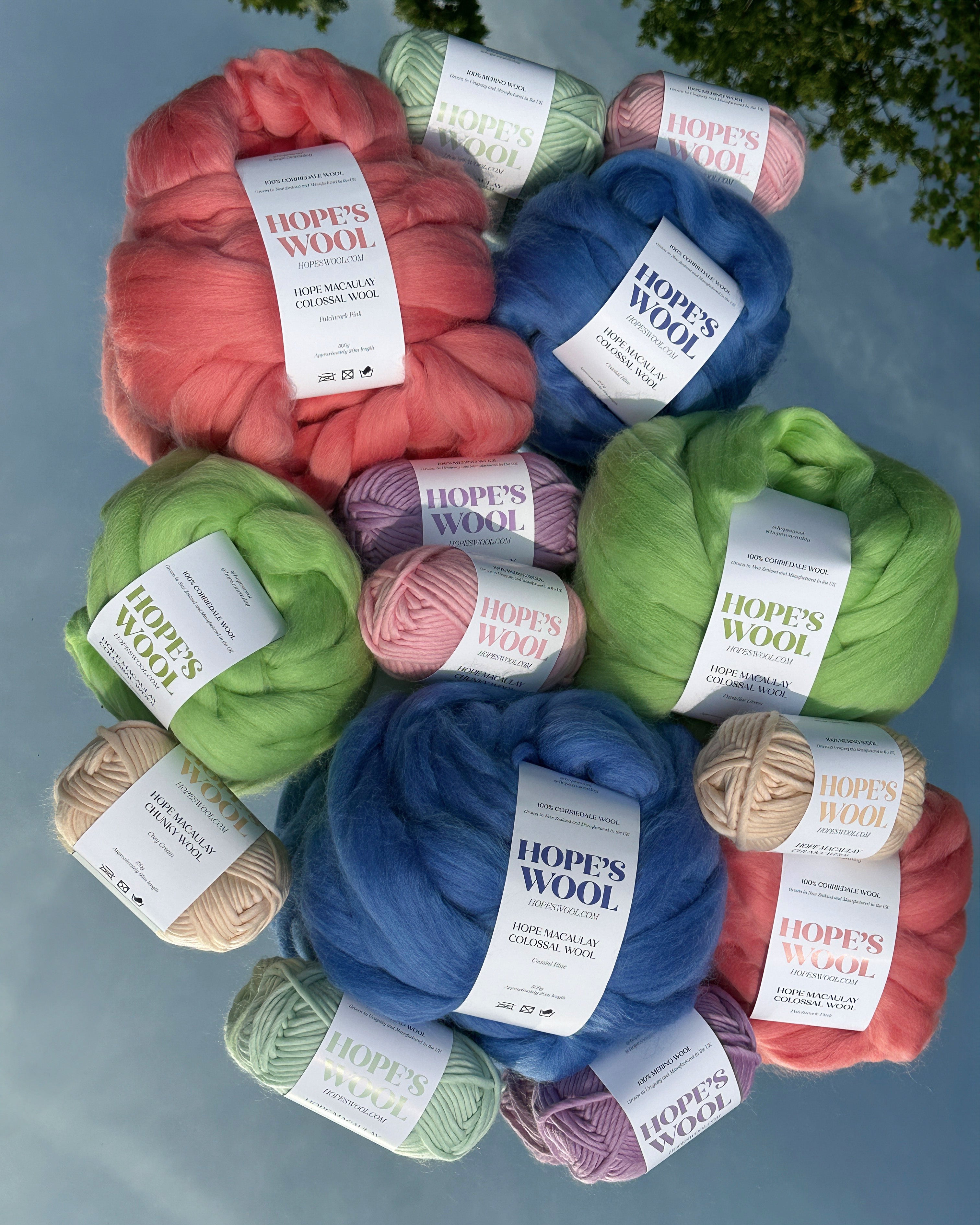 Balls of Corriedale wool in Pink, Blue and Green sitting on a mirror