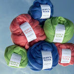 Balls of Corriedale wool in Pink, Blue and Green sitting on a mirror