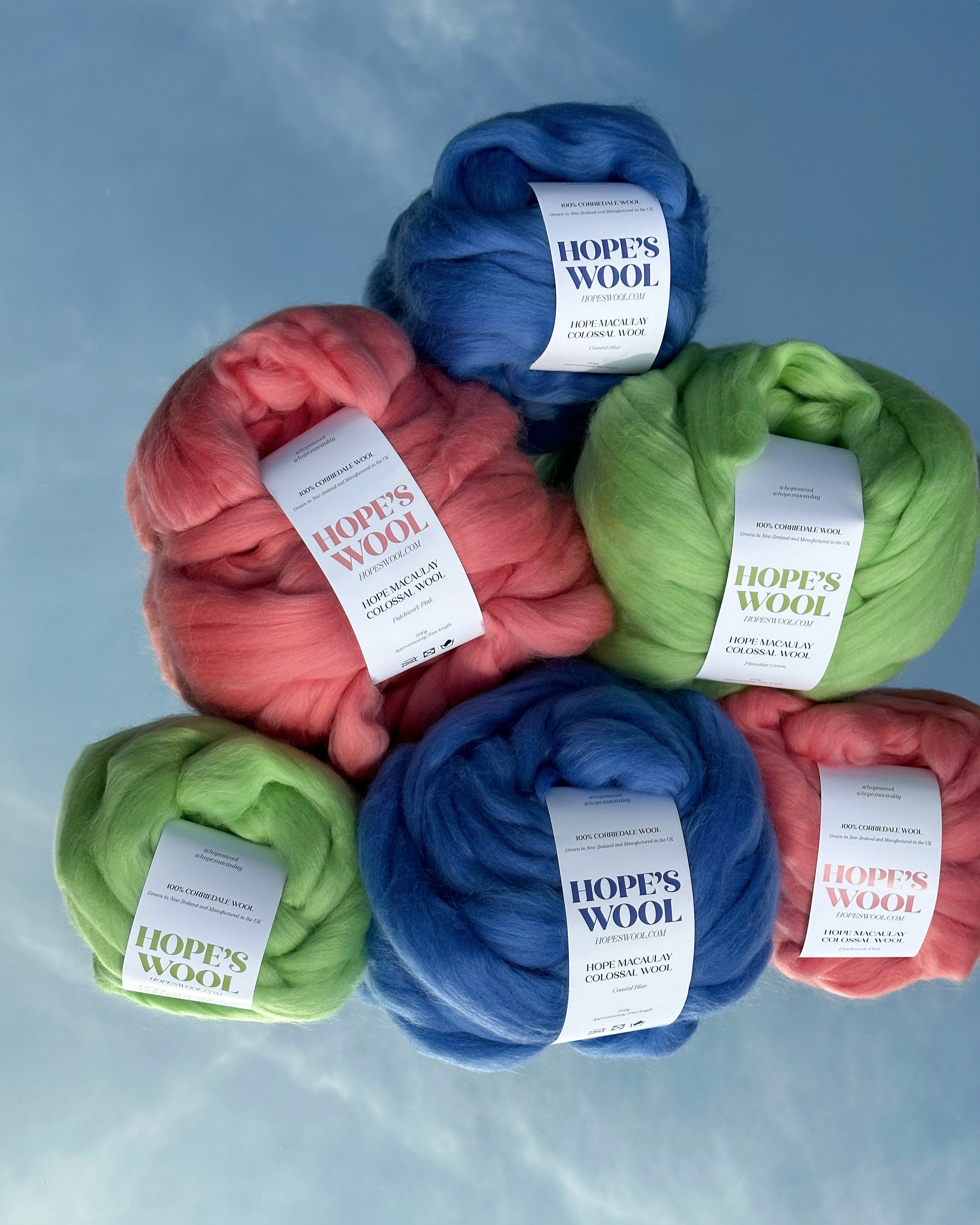 Balls of Corriedale wool in Pink, Blue and Green sitting on a mirror