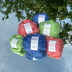 Balls of Corriedale wool in Pink, Blue and Green sitting on a mirror