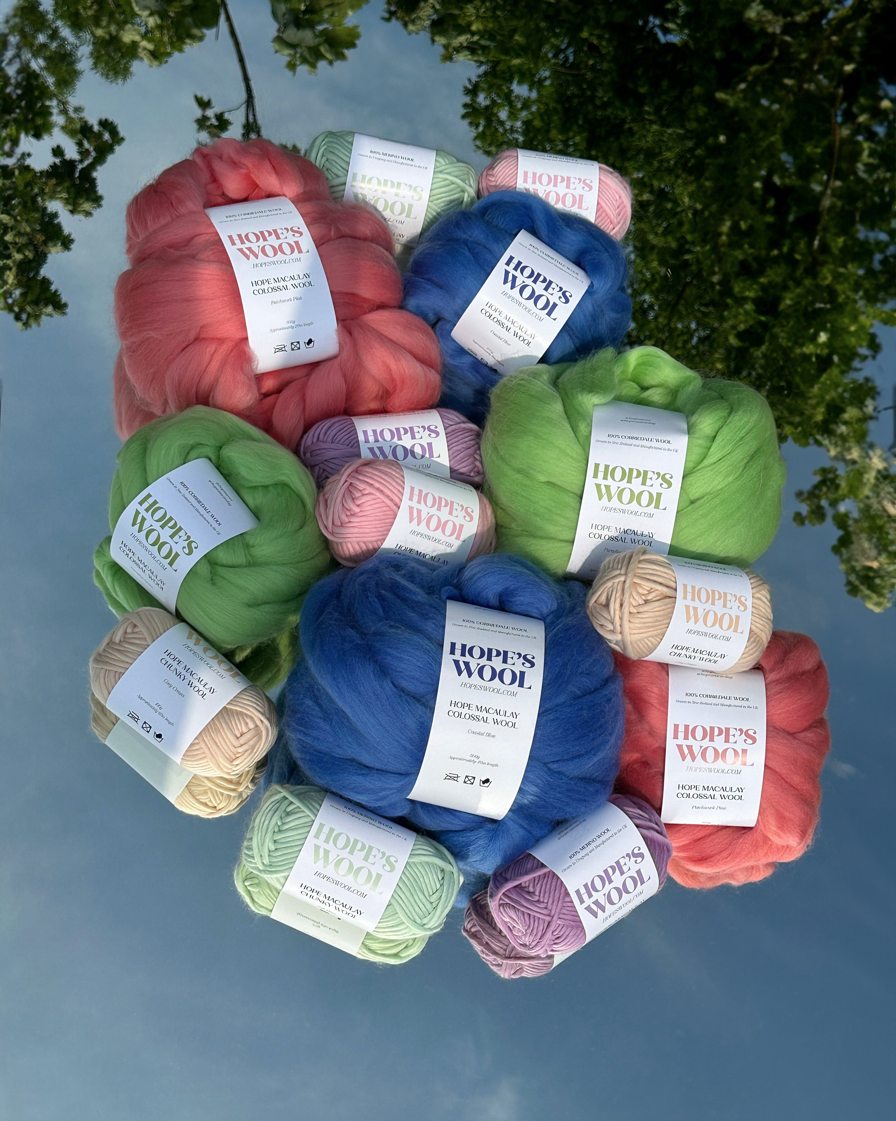 Balls of Corriedale wool in Pink, Blue and Green sitting on a mirror