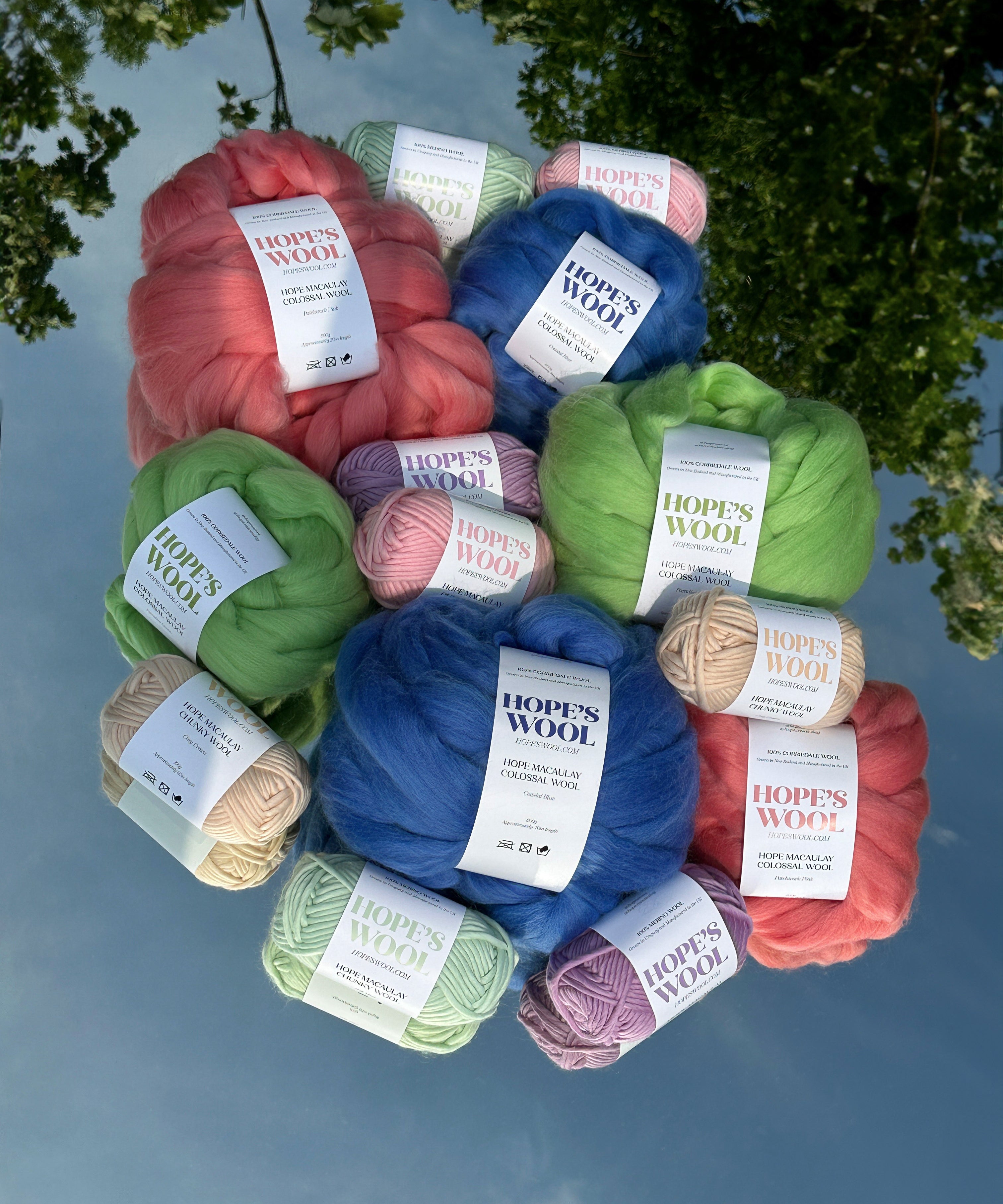 Balls of Corriedale wool in Pink, Blue and Green sitting on a mirror