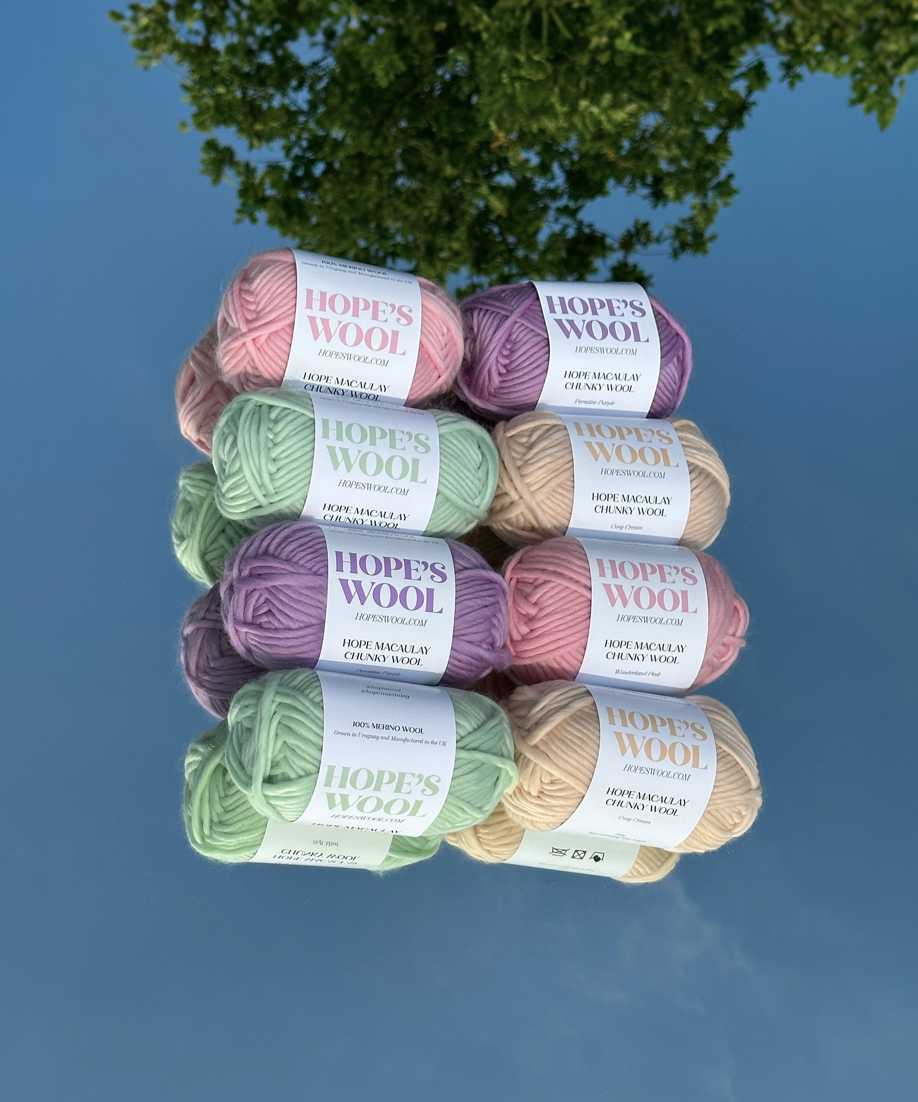 Balls of Merino wool in mint, pink, purple and cream sitting on a mirror